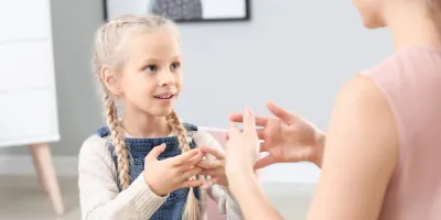 A speech therapist working with a young girl
